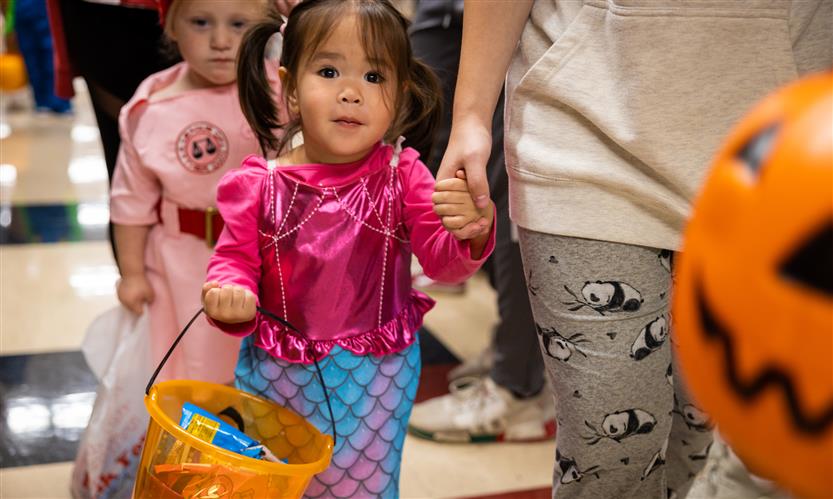 Children in costume trick or treat around school